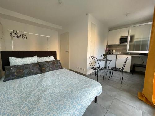 une chambre avec un lit et une table avec des chaises dans l'établissement Petit cocon Sètois ! Balcon avec vue et parking, à Sète