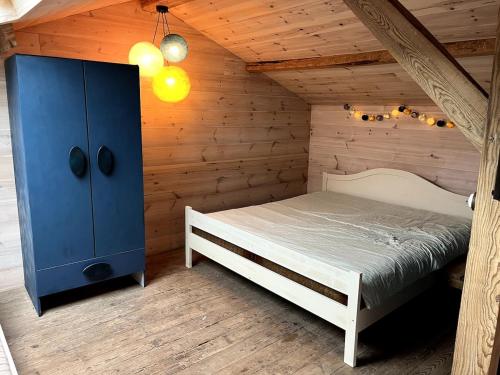 une chambre avec un lit dans une pièce en bois dans l'établissement La Grange Cirque, à Uza