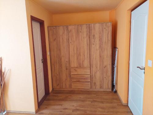 a wooden door in a room with a hallway at Bodza apartman in Gyula