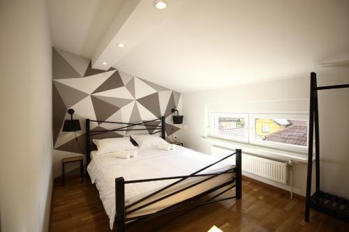 a bedroom with a large bed with a geometric wall at La Paloma Blanca in Tuzla