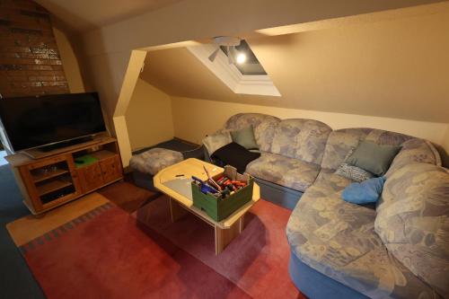 a living room with a couch and a tv at Pension Central in Bad Endbach