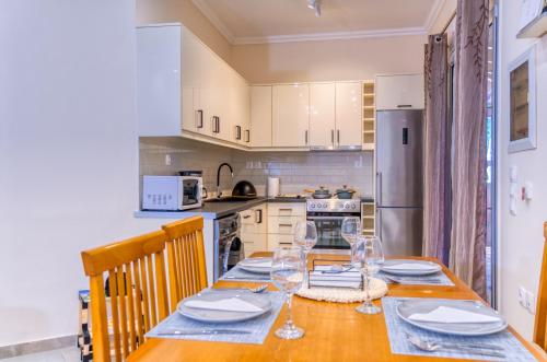 a kitchen with a wooden table with wine glasses on it at Villa Angela in Ágios Matthaíos