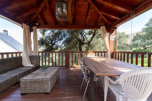 a wooden table and chairs on a deck at Villa con Jacuzzi exterior y Piscina cubiertos in Los Ángeles de San Rafael