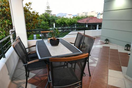 a table and chairs on a balcony with a view at Corinthian Green Villa in Vrahati