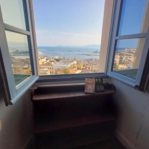 a window with a book and a remote control on a window sill at Palazzo Boyl 1840 in Cagliari
