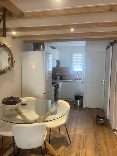 une cuisine avec une table en verre et des chaises dans une pièce dans l'établissement Villa club à proximité des calanques, à Bandol