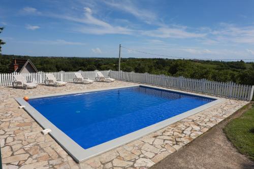 a swimming pool in a yard with a white fence at Teo-Sport in Cerovac