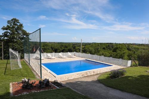 a pool with a volleyball net in a yard at Teo-Sport in Cerovac