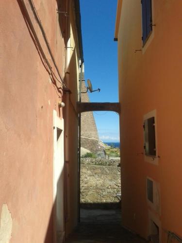 an alley with a view of the ocean from between two buildings at Terratetto Indipendente Capraia in Capraia