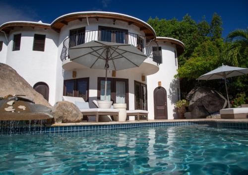 a villa with a swimming pool and a house at On The Rocks Villa in Spanish Town