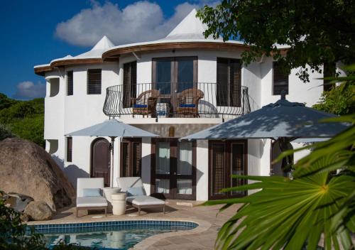 a large white house with a swimming pool in front of it at On The Rocks Villa in Spanish Town