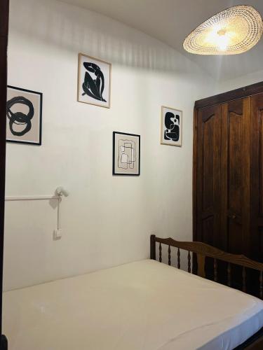 une chambre avec un lit et des tableaux au mur dans l'établissement Chez Lulu, à Cerbère
