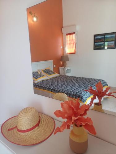 une chambre avec un lit et deux chapeaux sur une table dans l'établissement Gite 4 à 5 personnes sur domaine vinicole avec piscine chauffée - Vineyard cottage - heated pool, à Mormoiron