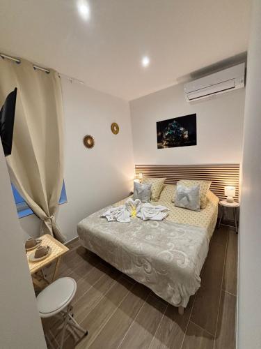 - une petite chambre avec un lit, une table et un bureau dans l'établissement La Topaze, à Narbonne