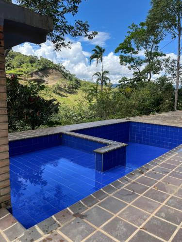 a blue tile swimming pool with a bench at Finca de Majo in Mocoa