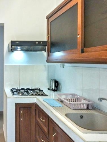 a kitchen with a sink and a stove top oven at Cozy Grand Baie Beach Apartment in Grand Baie