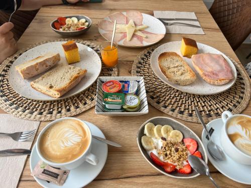 a wooden table with plates of food and cups of coffee at Casal de pelaio in Barreiros