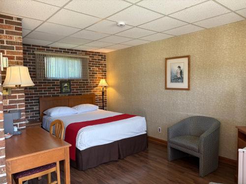 シェルブルックにあるMotel & Hotel La Paysanneのベッドと机があるホテルの部屋