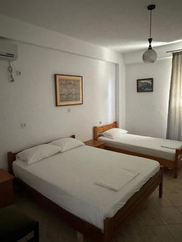 a bedroom with two beds and a window at Vila Rapo in Himare