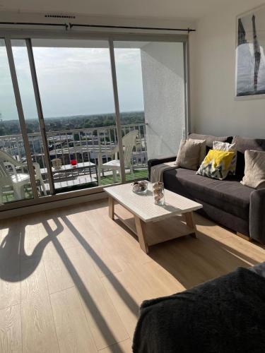 a living room with a couch and a coffee table at En hauteur, au pied du métro & 7mn du centre Lille in Mons-en-Baroeul