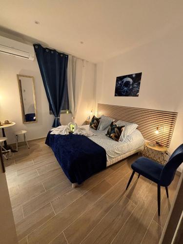 une chambre avec un grand lit et une chaise dans l'établissement La Saphir, à Narbonne