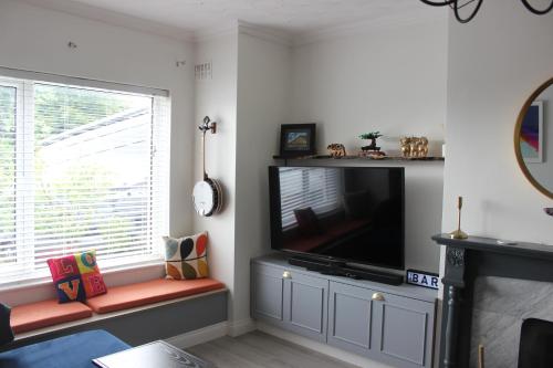 a living room with a flat screen tv and a window at Bright & Cozy Home in Knocknacarra in Galway