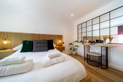 a bedroom with a large white bed and a desk at The Flat - Brand new renovation in amazing location in St. Agnes