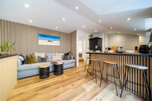 a kitchen and living room with a blue couch at The Flat - Brand new renovation in amazing location in St. Agnes