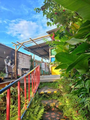 a patio with a red fence and some plants at Kimaná Hostal in Santa Rosa de Cabal