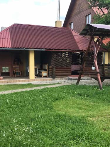 a building with a picnic table in the grass at Перлина in Pilipets