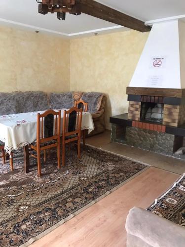 a living room with a table and a fireplace at Перлина in Pilipets
