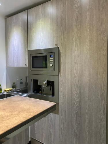 La cuisine est équipée d'un four micro-ondes et de placards en bois. dans l'établissement Deauville plein coeur, à Deauville