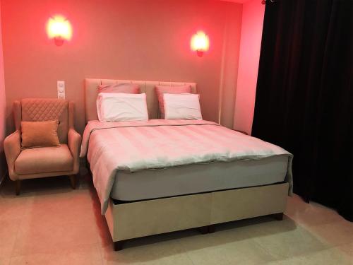 a pink bedroom with a bed and a chair at Hôtel-Restaurant Belle'man in Longevelle-sur-Doubs
