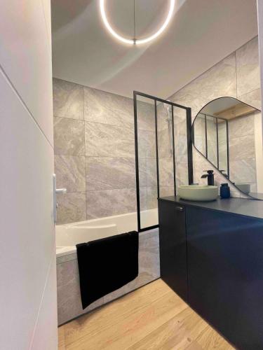 une salle de bain avec un lavabo et une baignoire dans l'établissement Appartement standing mas en pierre traditionnel, à Clapiers