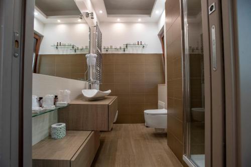 ナポリにあるRione Alto City Houseのトイレ、洗面台、鏡のあるバスルーム