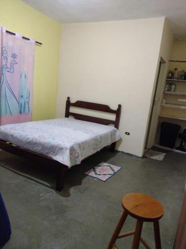 - une chambre avec un lit, une table et un tabouret dans l'établissement Cantinho da Fla, à Itanhaém