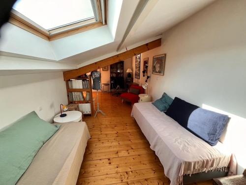 - un salon avec deux lits et une lucarne dans l'établissement Maison familiale à 100 m de la plage, à Châtelaillon-Plage