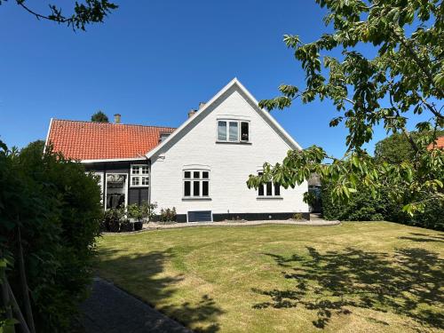 a white house with a red roof at Revninge Guesthouse in Revninge