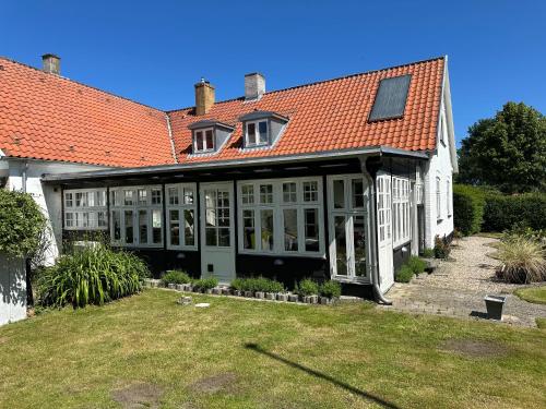 a large white house with an orange roof at Revninge Guesthouse in Revninge