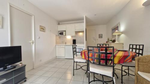 a living room with a table and chairs and a kitchen at Saint Georges de Didonne - CONFORTABLE APPARTEMENT - La Dune Plein Sud in Saint-Georges-de-Didonne
