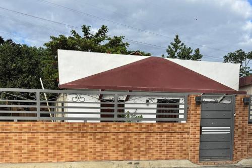 a building with a red roof and a brick wall at enjoy the nature of the countryside in Bonao