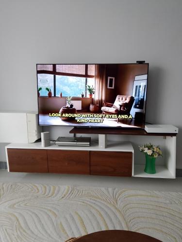 a living room with a flat screen tv on a table at Sabaki's Homely One bedroom Apartment - Near JKIA, Airport in Marimbeti
