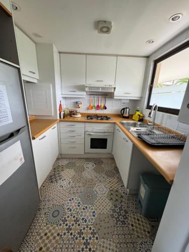 a kitchen with white cabinets and a tile floor at San Alfonso del Mar 2D2B complemente remodelado in San Antonio
