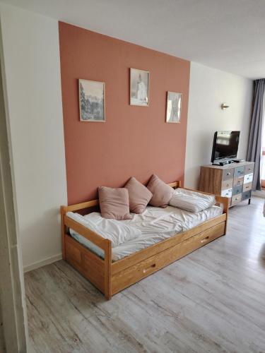 - une chambre avec un lit en bois et des oreillers dans l'établissement Studio 4 pers pied des pistes, à Bagnères-de-Bigorre