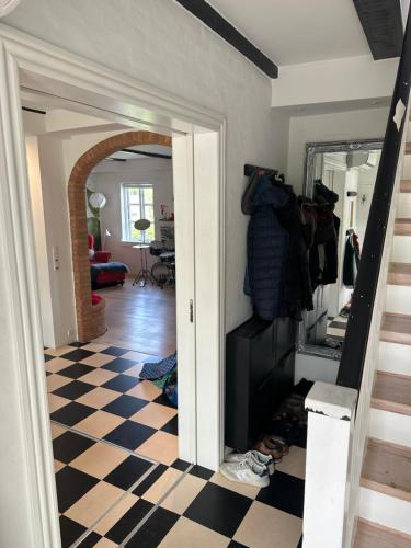 a room with a checkered floor and a hallway at Revninge Guesthouse in Revninge