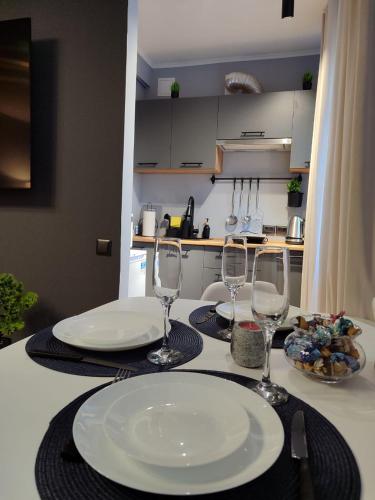 a table with two plates and wine glasses on it at Kosmonaudi Apartment in Narva
