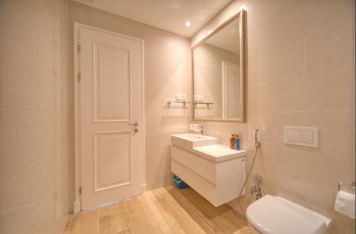 a bathroom with a toilet and a sink and a mirror at Lustica Bay Marina Village by 2BHome in Lustica