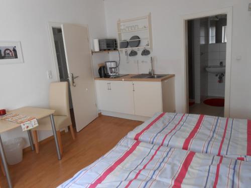 Zimmer mit einem Bett und einem Tisch sowie einer Küche in der Unterkunft Main(schlaf)erlebnis in Karlstadt
