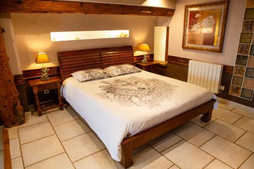 a bedroom with a large bed and two night stands at Chambres d'hôtes Le Repère des Anges et SPA in Larnod