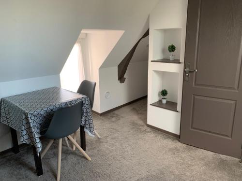une pièce avec une table, des chaises et une porte dans l'établissement Chambre chaleureuse avec accès indépendant et sanitaires indépendants, à La Menitré